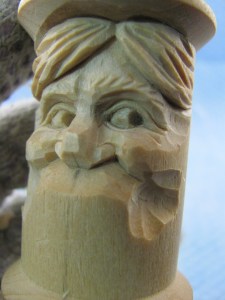 Even though the spool is round, the mouth and teeth must fit the head. Remember grandpa’s dentures were not as wide as his head. We’re going to concentrate on the dental mound. Use an 10mm #11gouge to deepen the area under each cheek. Because the muscles stretch the mouth a little, the mouth will be a little wider than the distance between the center points of the eyes. Use a knife to shape the upper lip back into the area prepared under the cheeks. Draw the lip line. Notice the ends do not touch the expression lines that form the cheeks.